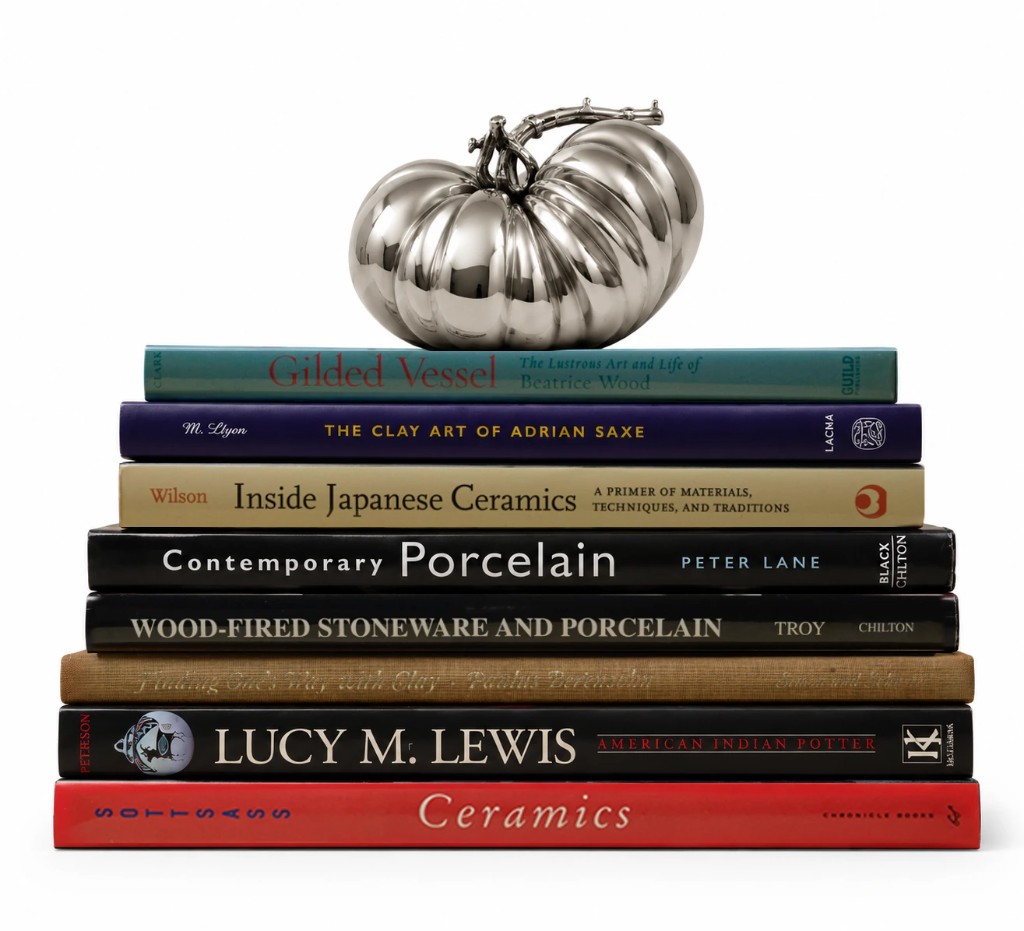 PCPW polished silver tomato paperweight on a stack of ceramics books — Philip Cronerud